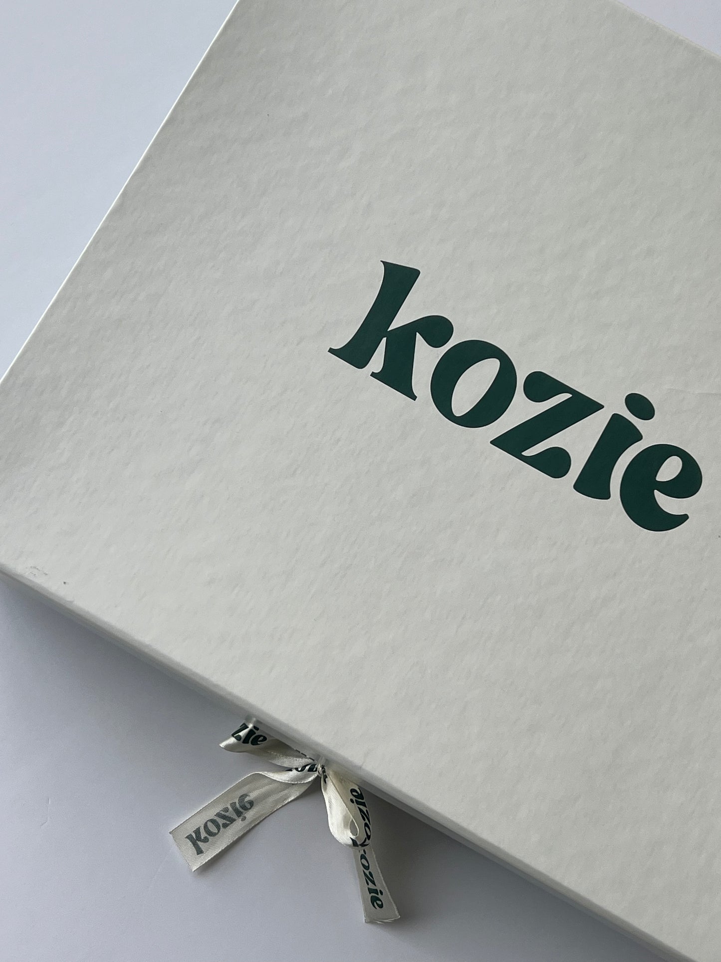 Closed Kozie keepsake box in sage green with the embossed logo