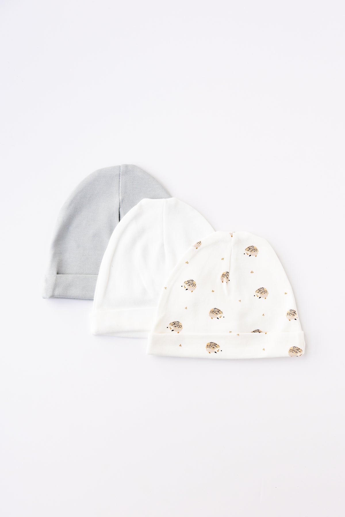 Three baby hats in grey, white and Hedgehog Meadow print