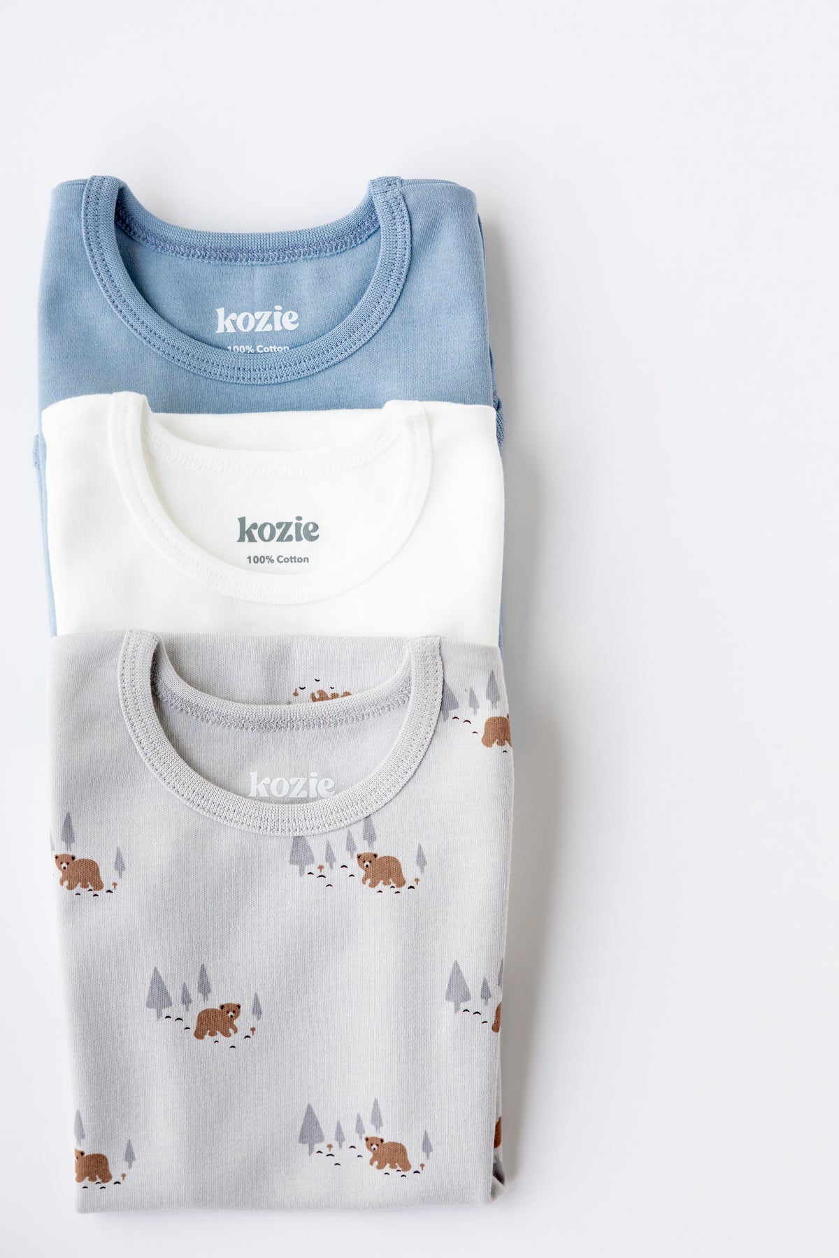 Three sleeveless bodysuits in dusty blue, white and Woodland print