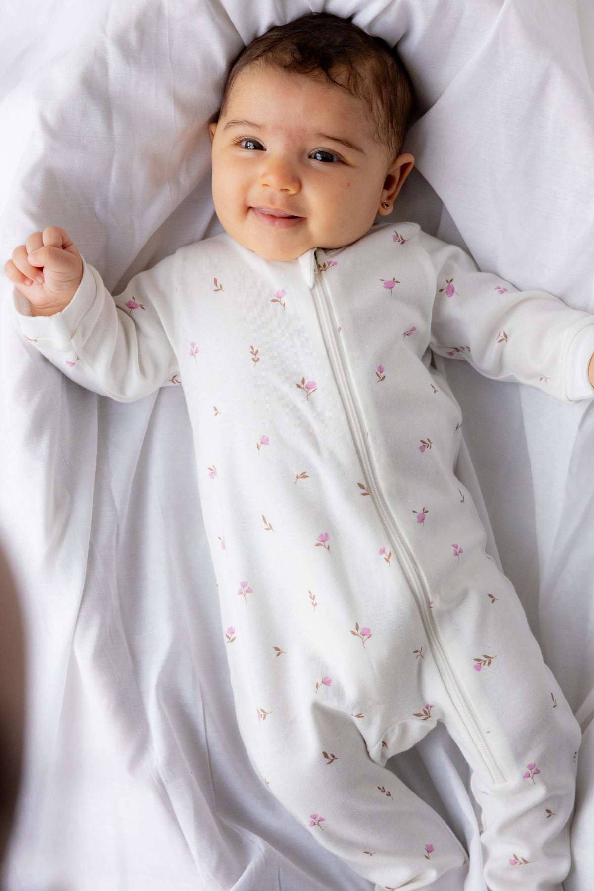 Baby lying down in the Winter Floral footed zipper sleepsuit