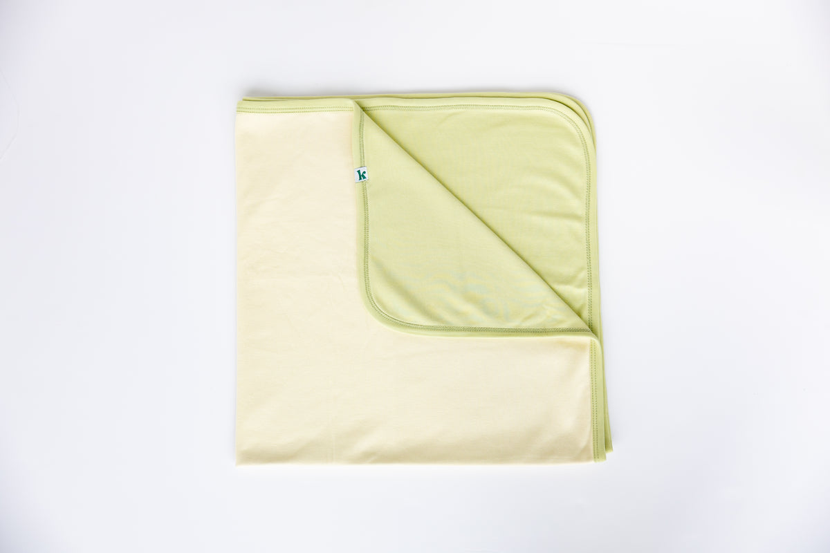 Sage and natural double-sided cotton baby blanket, folded to show both sides