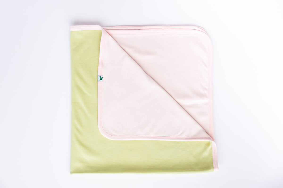 Blush and sage double-sided cotton baby blanket, folded to show both sides
