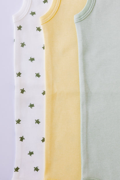 Turtle Bay print sleeveless bodysuit laid flat beside a butter yellow pair