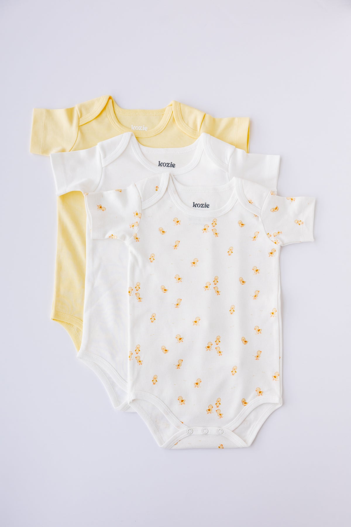Three short sleeve bodysuits in butter yellow, white and Ducky Days print