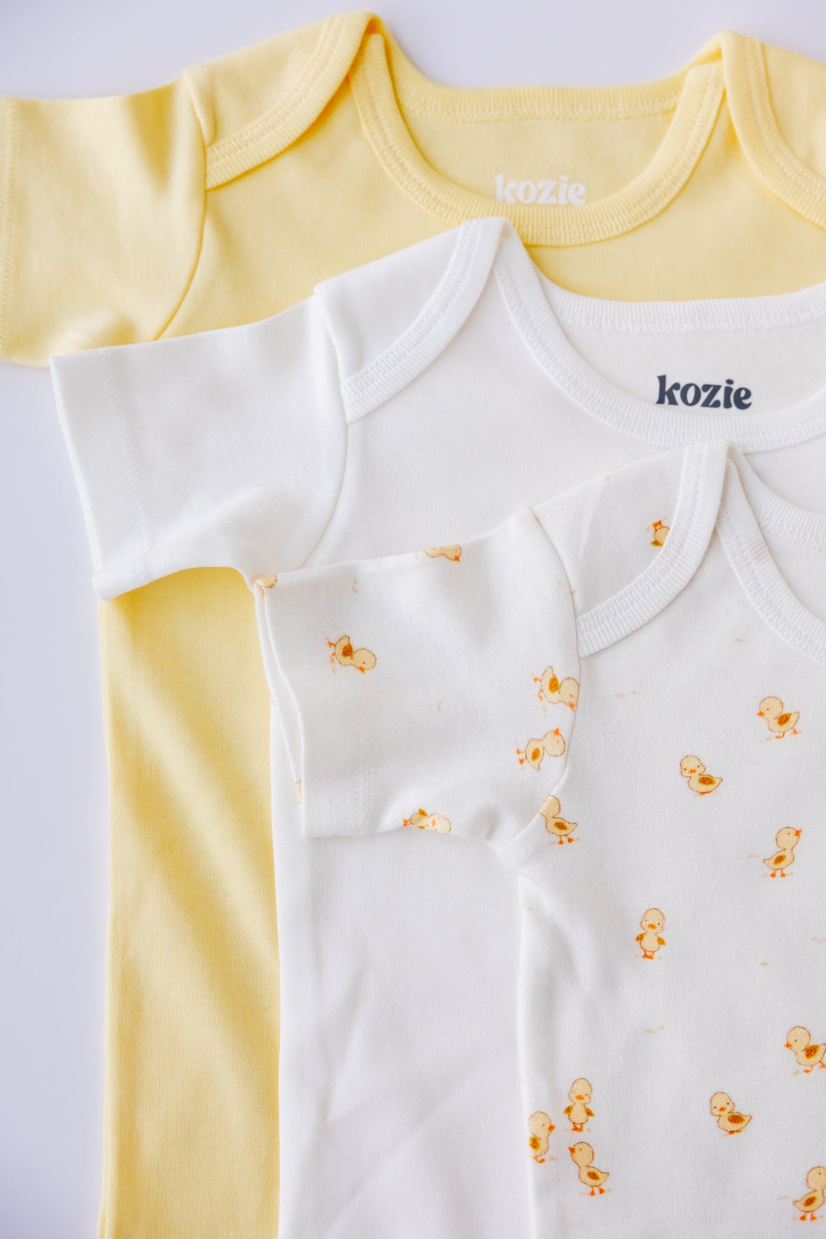 Ducky Days short sleeve bodysuits folded in yellow and white