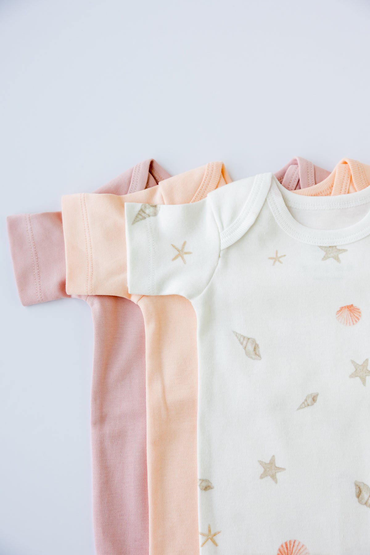 Seashell Blush short sleeve bodysuits folded and stacked