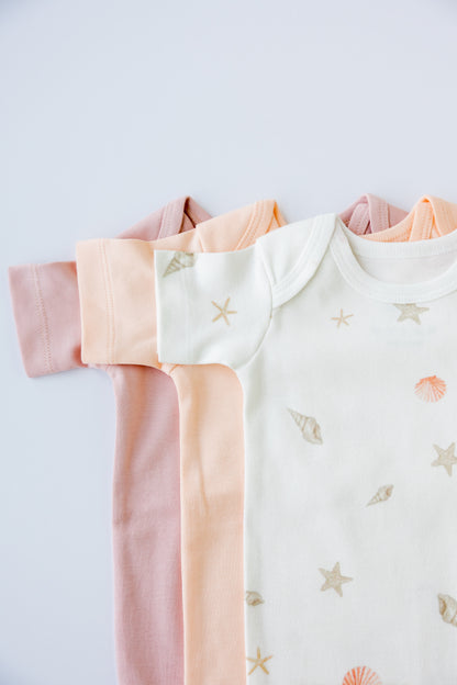 Seashell Blush short sleeve bodysuits folded and stacked