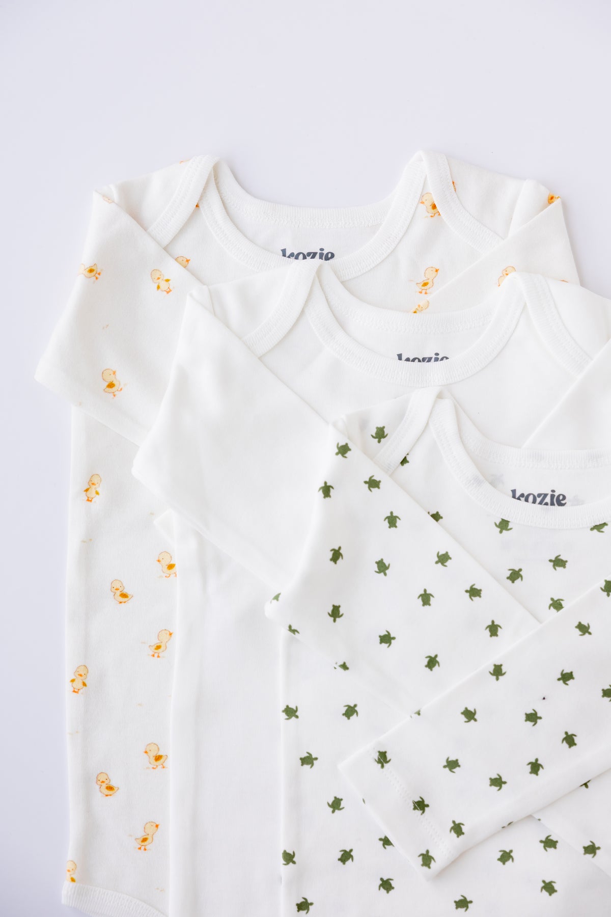 Three long sleeve bodysuits in white and Tiny Explorer print