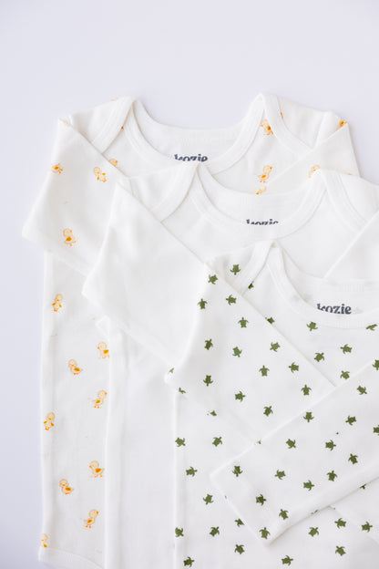 Three long sleeve bodysuits in white and Tiny Explorer print