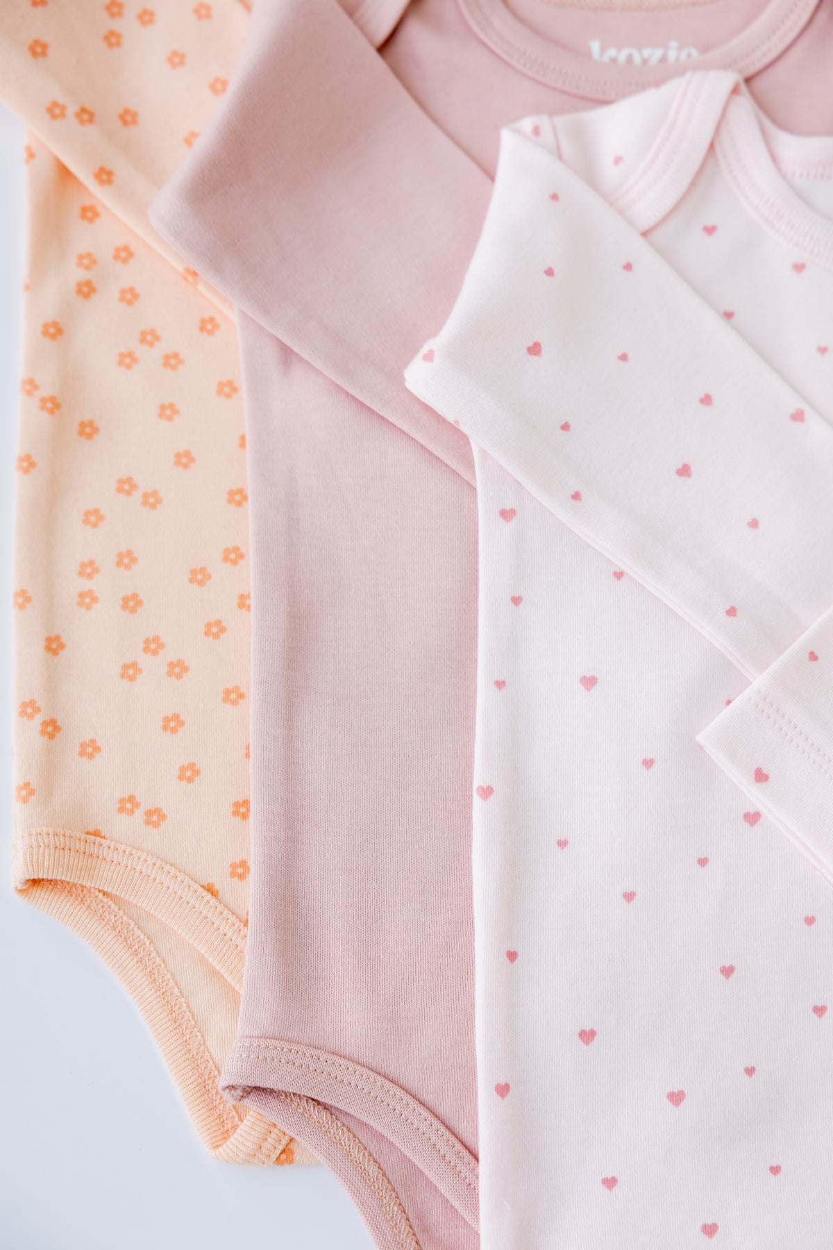 Sweet Hearts print long sleeve bodysuits, laid flat