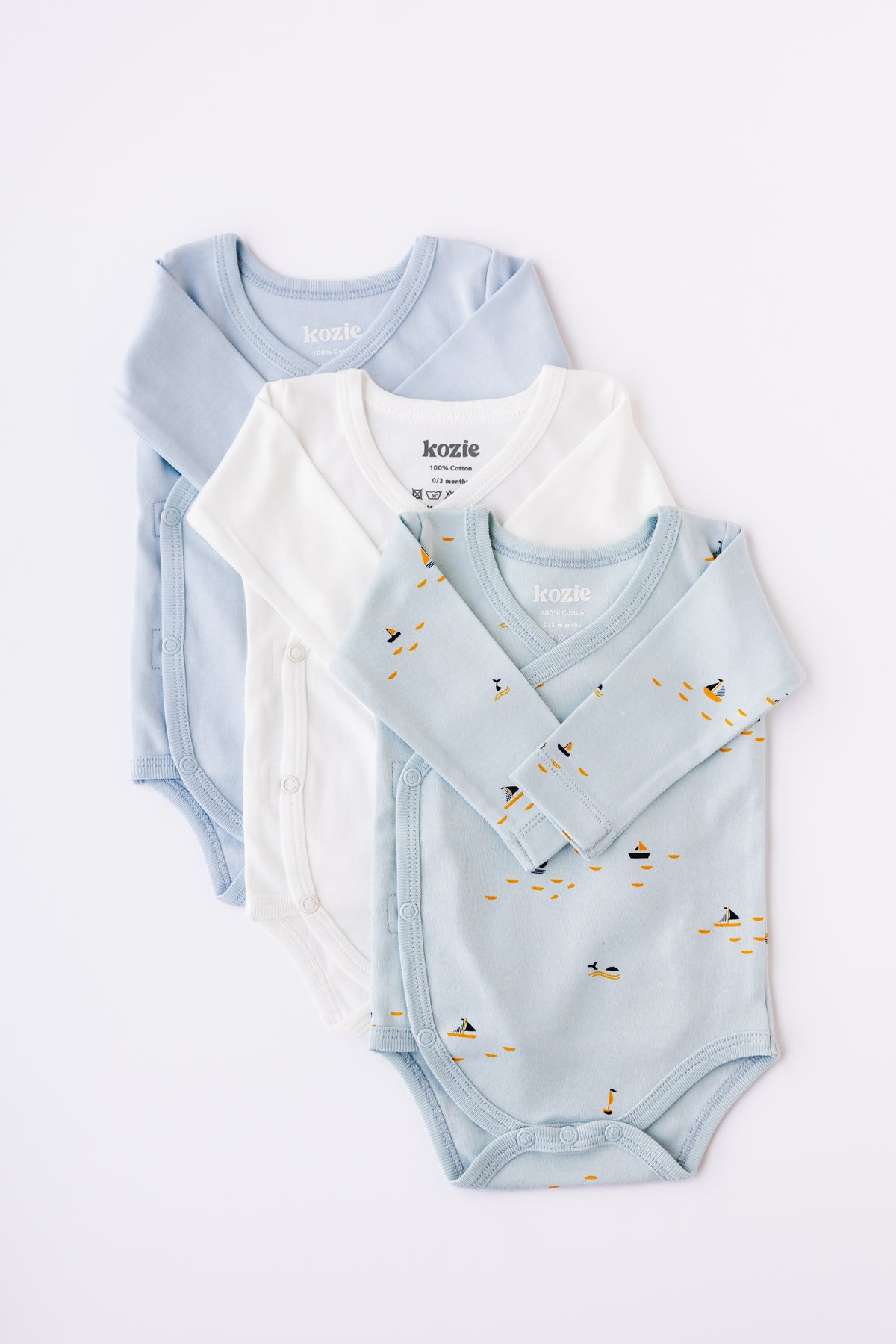 Three long sleeve kimono bodysuits in sky blue, white and Blue Sails print