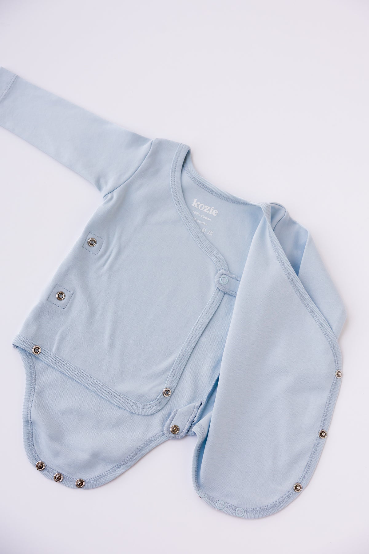 Close-up of the wrap front on a sky blue long sleeve kimono bodysuit