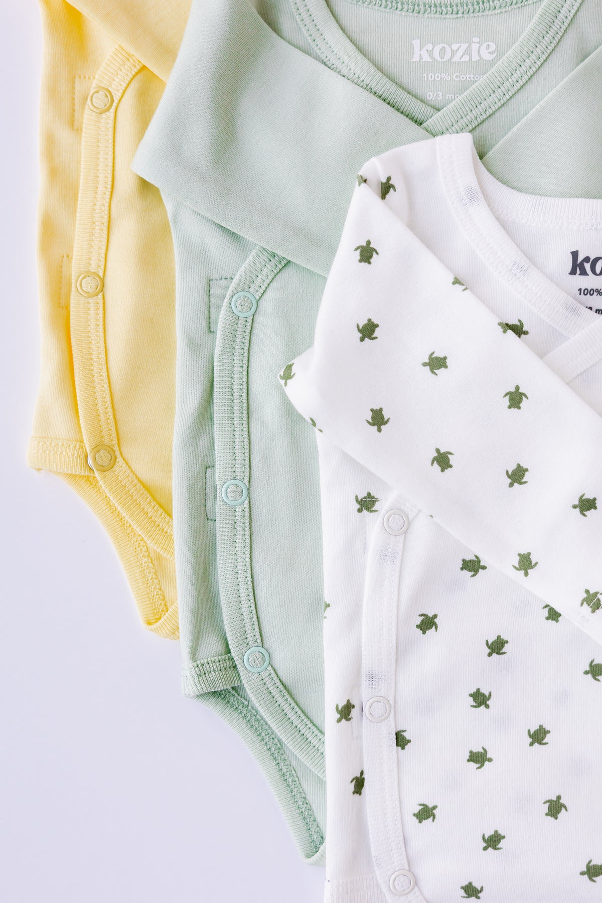 Turtle Bay print kimono bodysuit laid flat beside a sage pair