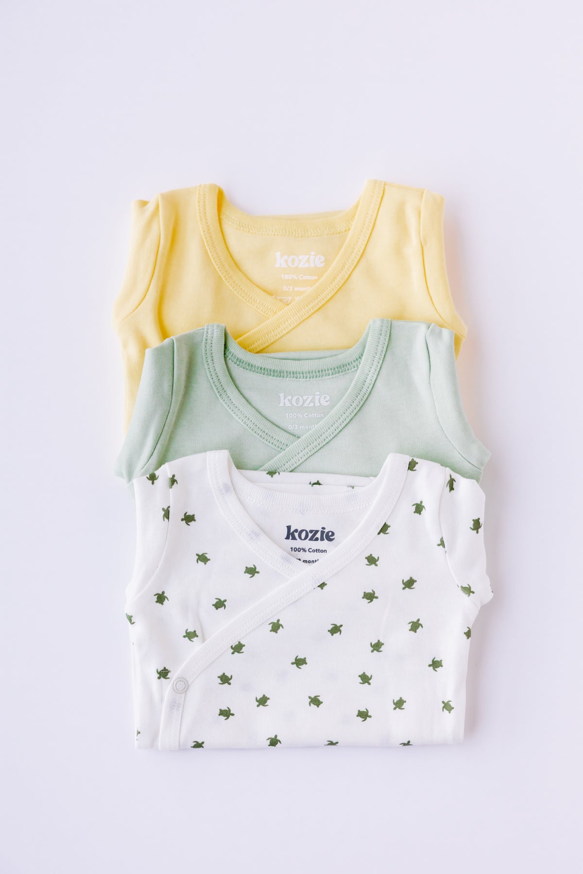 Turtle Bay kimono bodysuits folded and stacked in sage and yellow