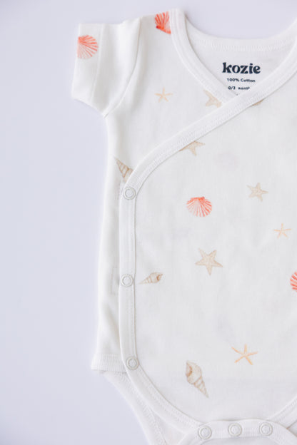 Close-up of the wrap front and Kozie label on a Coastal Day Dream kimono bodysuit