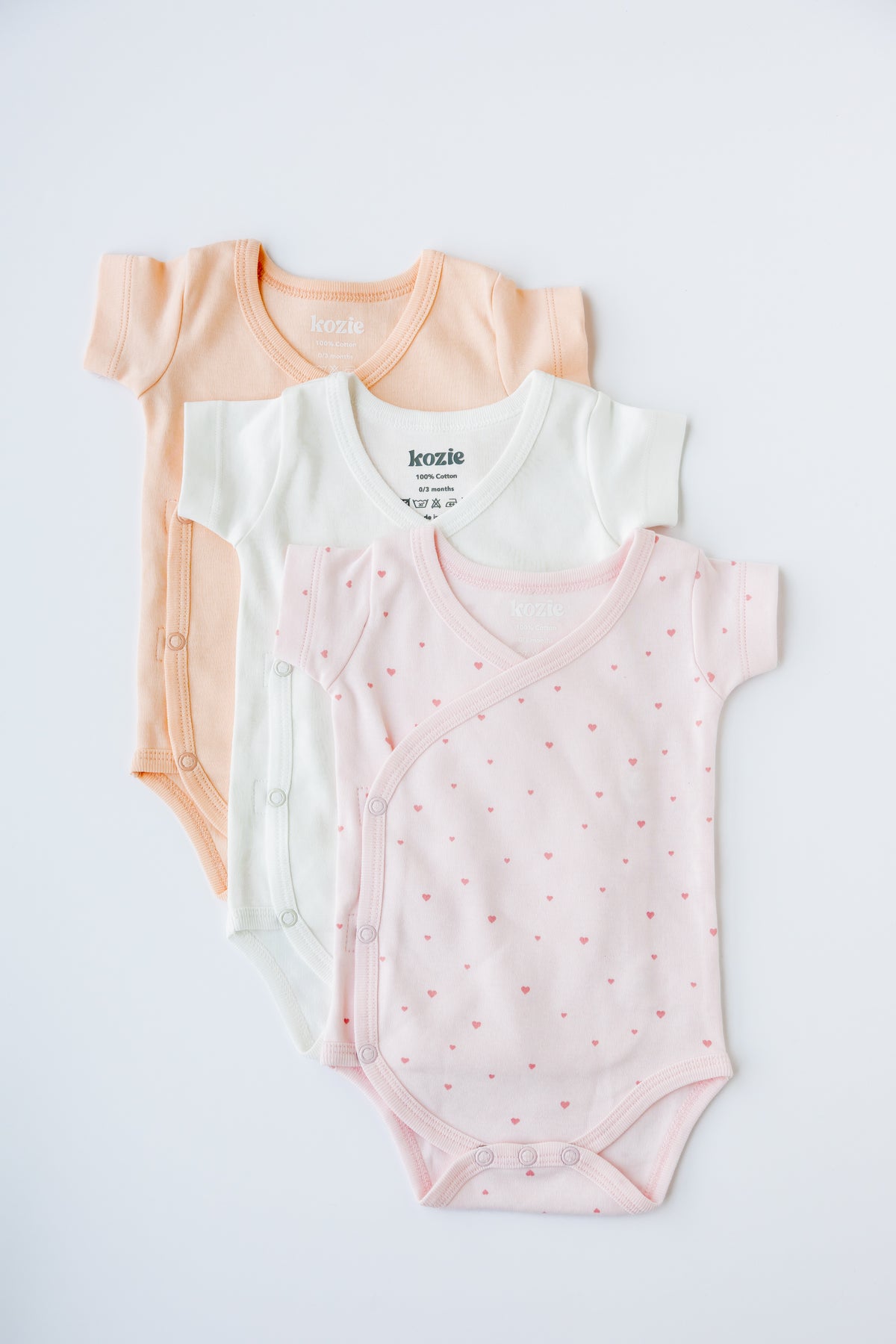 Three short sleeve kimono bodysuits in coral, white and Tiny Love print