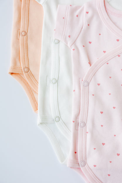 Close-up of the Tiny Love print on a blush kimono bodysuit