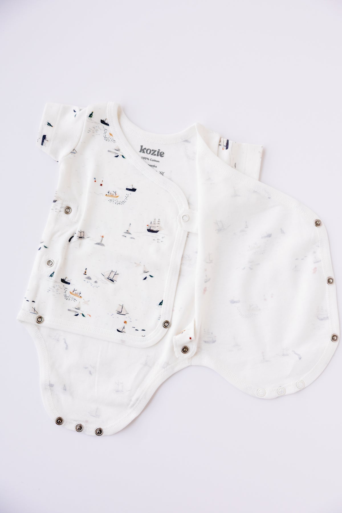 Little Voyage kimono bodysuit and shorts set arranged on a pale background