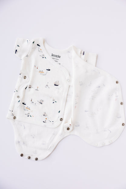 Little Voyage kimono bodysuit and shorts set arranged on a pale background