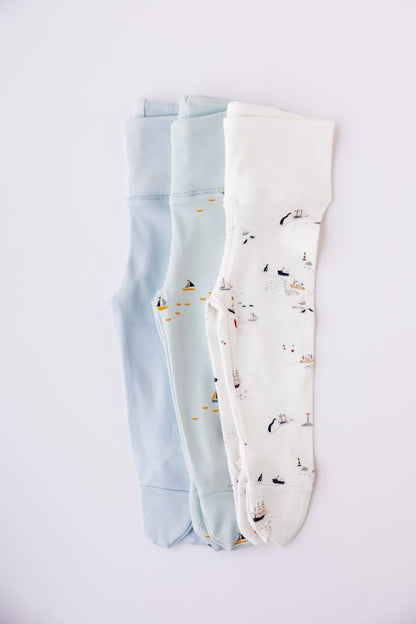 Three pairs of footed leggings in sky blue, white and Sailing Days print