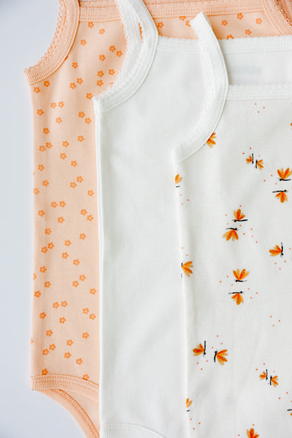 Two Daisy Dreams print sleeveless bodysuits, laid flat