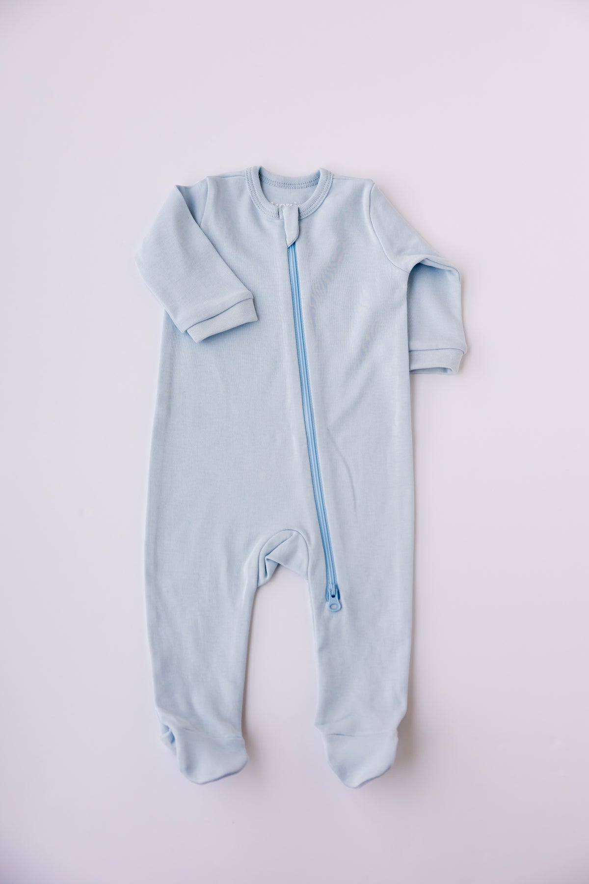 Sky blue footed zipper sleepsuit laid flat, showing the full-length zip