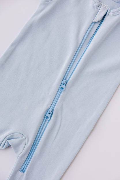 Close-up of the two-way zip on the sky blue footed sleepsuit