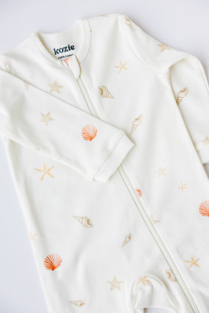 Close-up of the Sea Shells print and zip on the white sleepsuit