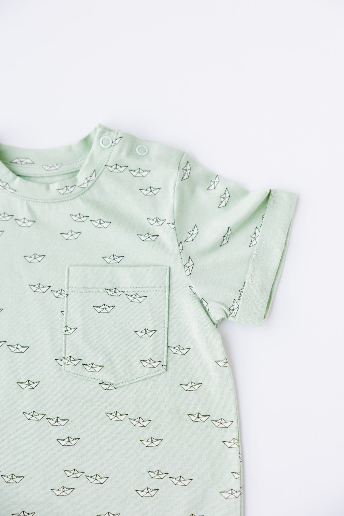 Close-up of the Paper Boats print on the sage romper