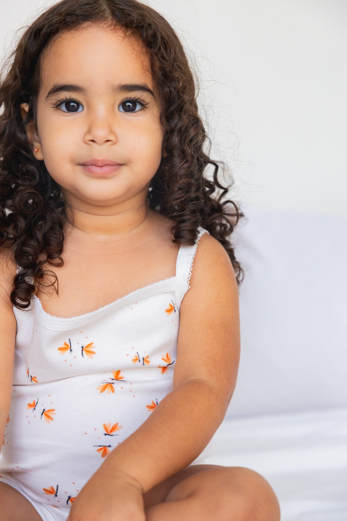 Toddler sitting in the Daisy Dreams sleeveless bodysuit