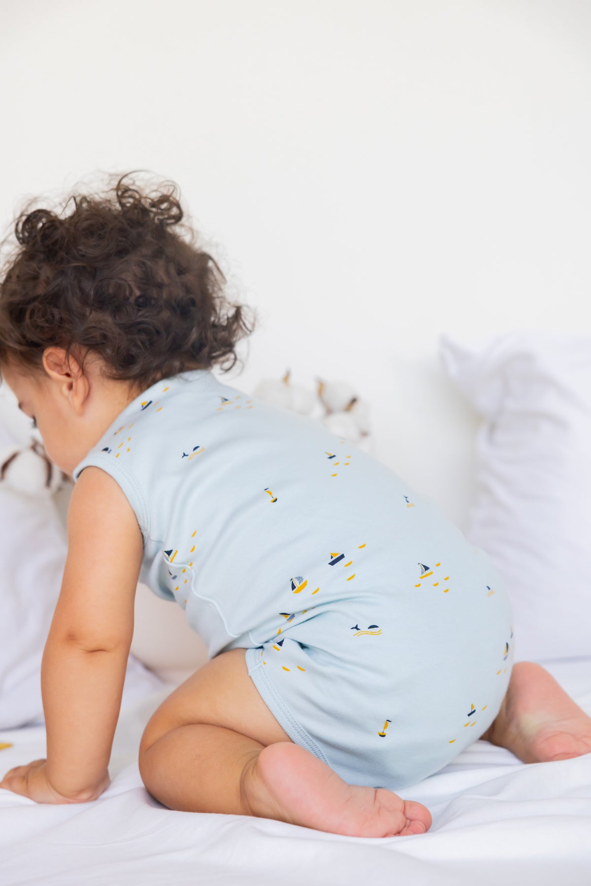 Toddler sitting in a Blue Sails print sleeveless bodysuit