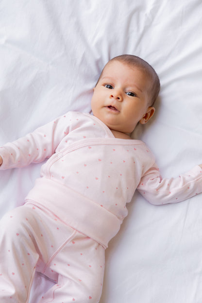 Baby lying down in blush footed leggings