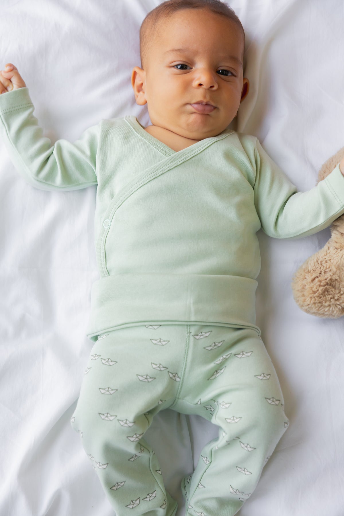Baby lying down in sage footed leggings and a matching top