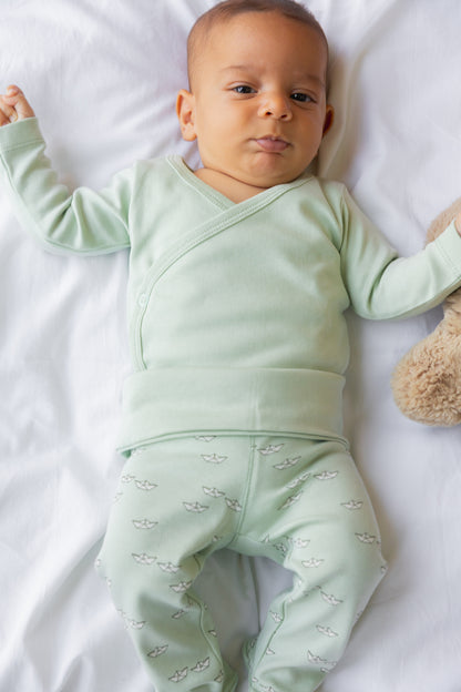 Baby lying down in sage footed leggings and a matching top