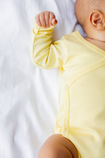 Baby in a butter yellow long sleeve kimono bodysuit