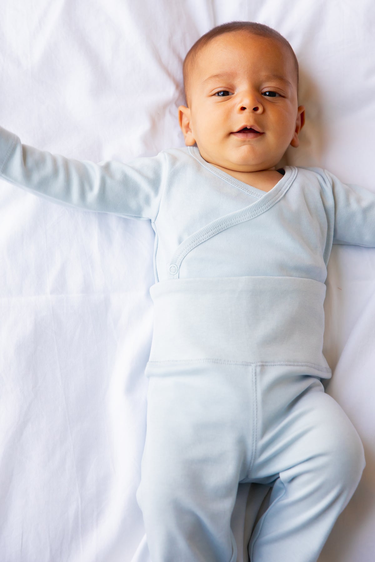 Baby lying down in sky blue footed leggings