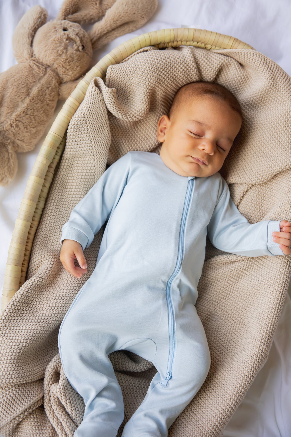 Baby asleep in the sky blue footed zipper sleepsuit