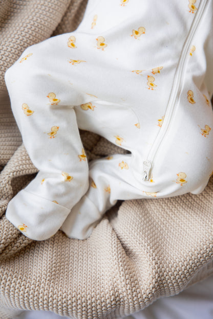 Ducky Days sleepsuit draped over a blanket, showing the footed cuffs