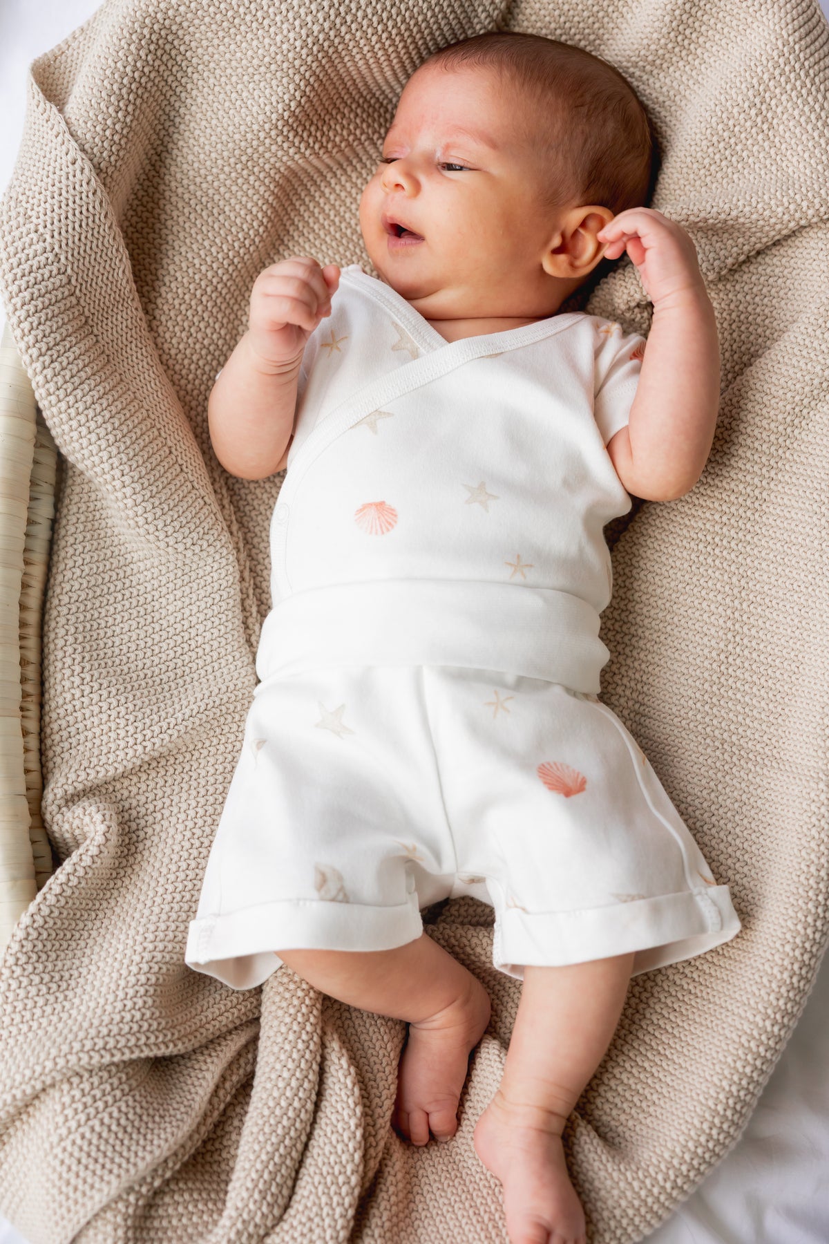 Newborn asleep in the Sea Shells kimono bodysuit and shorts