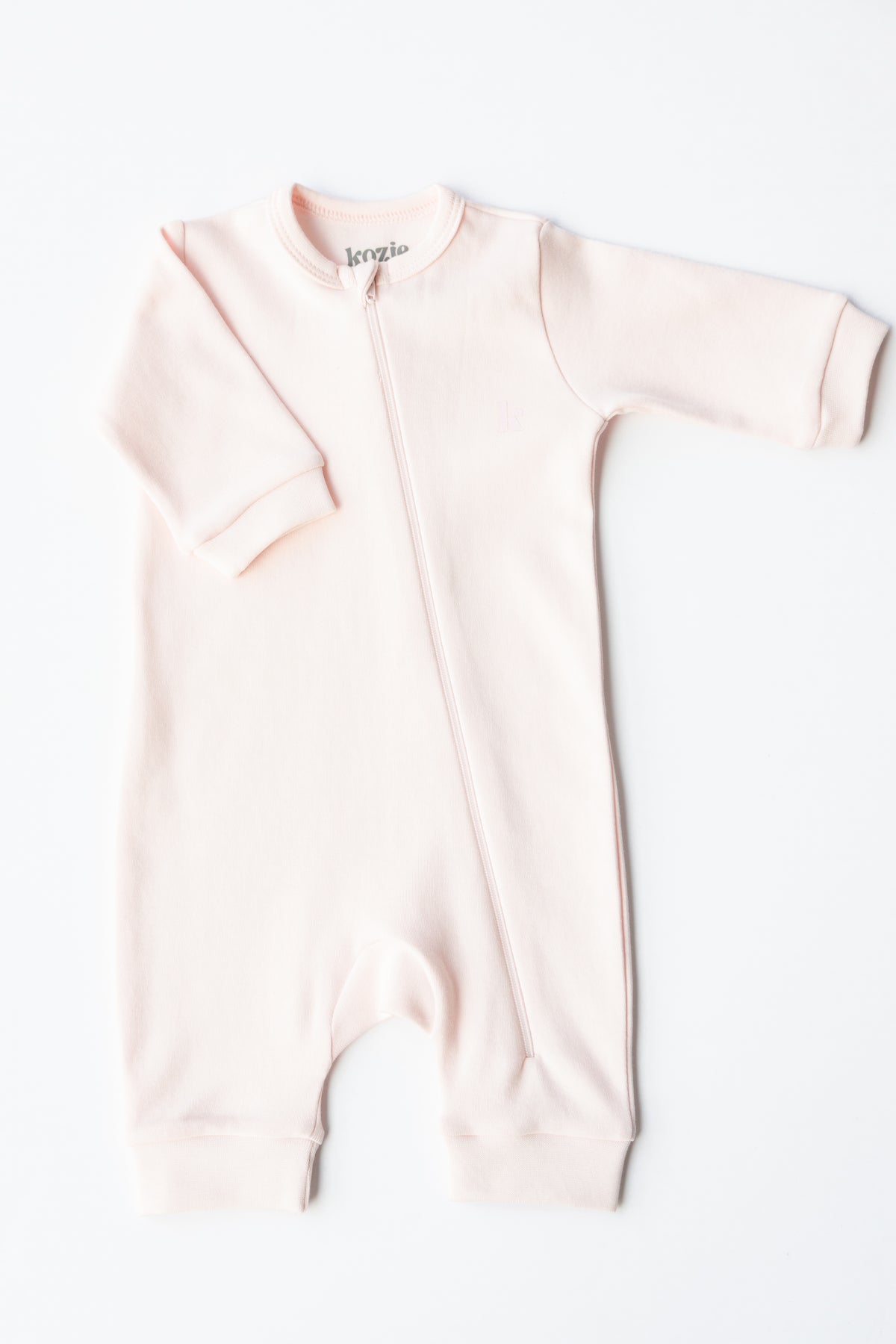 Blush zipper sleepsuit laid flat, showing the full-length zip