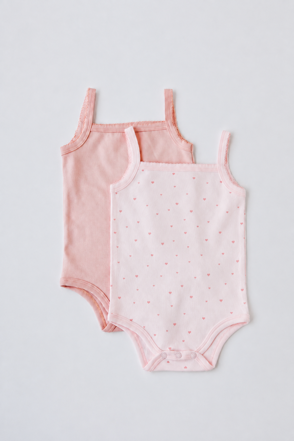 Two sleeveless bodysuits in blush and Tiny Love print