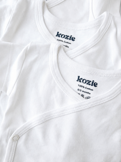 Close-up of the wrap neckline and Kozie label on a white kimono bodysuit