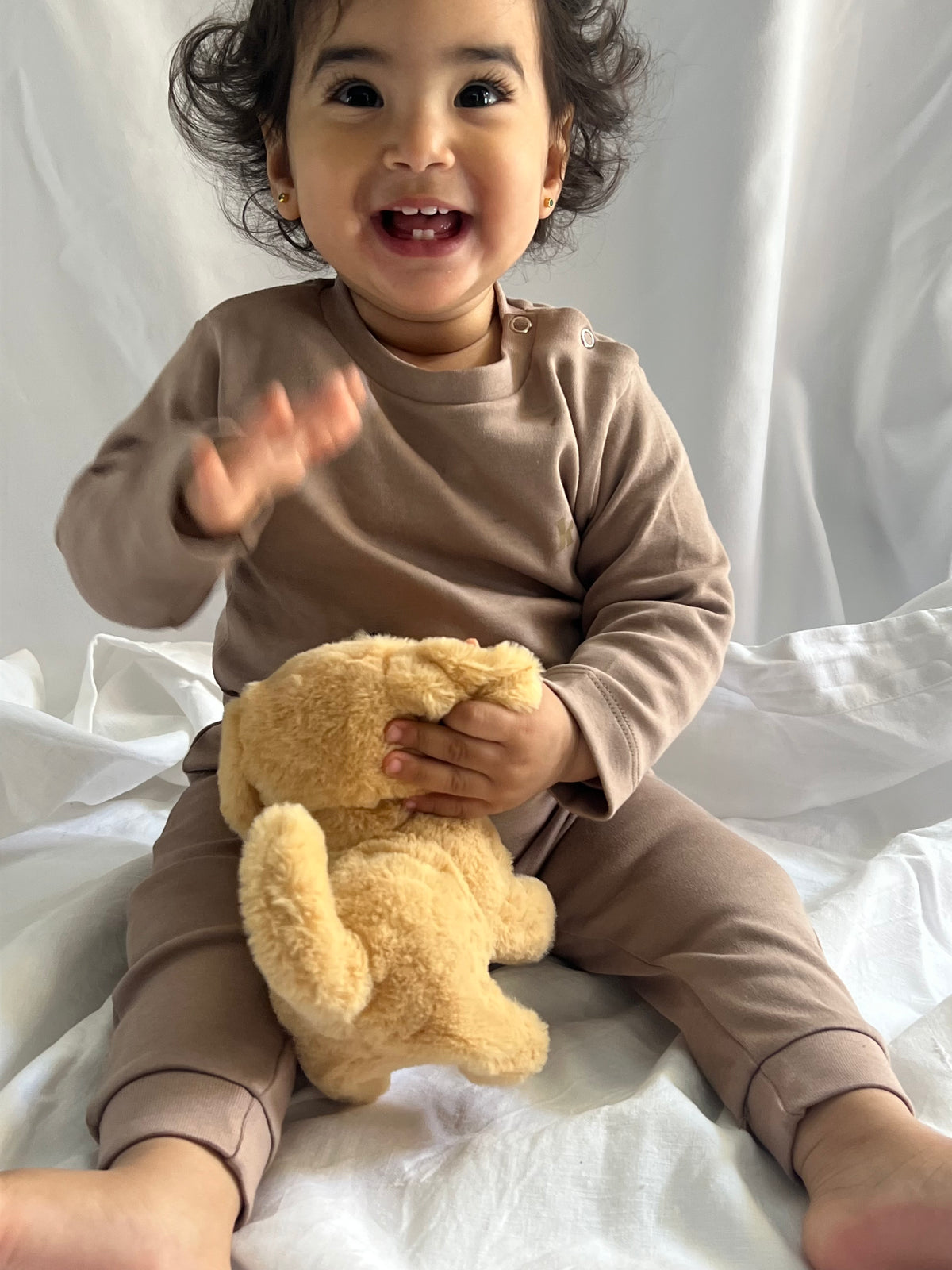 Toddler holding a teddy bear in the cocoa long sleeve pyjama set