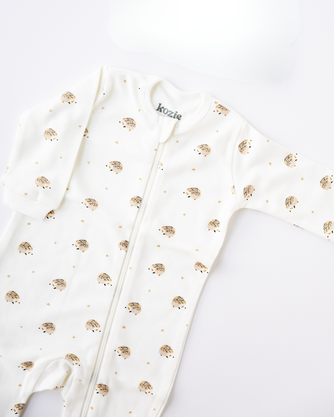 Hedgehog Meadow print footed zipper sleepsuit, laid flat