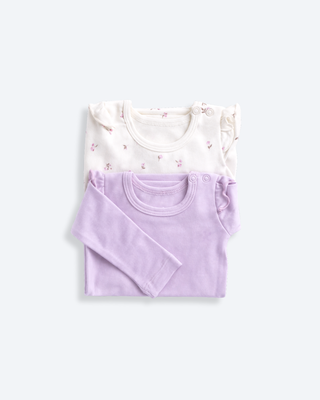 Two ruffle-shoulder bodysuits in white and lavender, laid flat