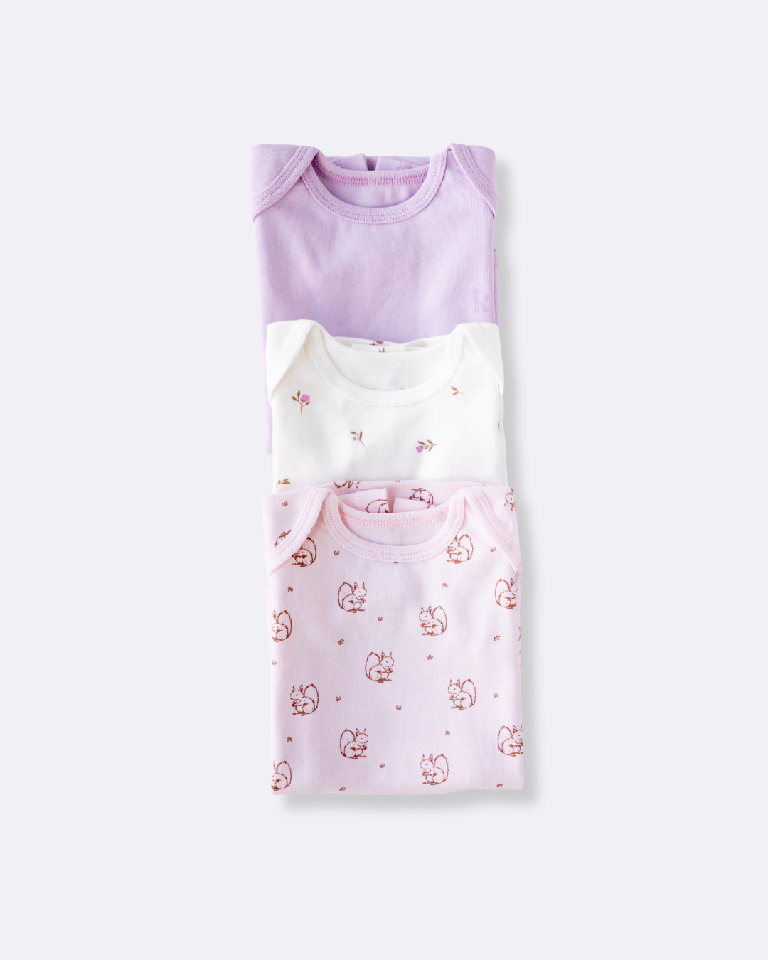 Three short sleeve bodysuits in lavender, white and Meadow Blossoms print