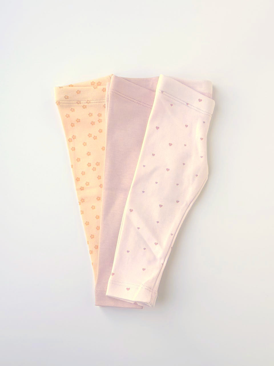 Three pairs of baby leggings in blush, cream and Sweet Hearts print
