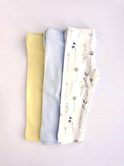 Three pairs of baby leggings in butter yellow, white and Wildflower print